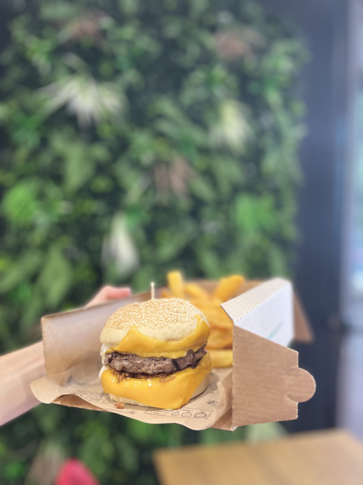 Cheese burger coulant devant le mur végétal